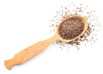 Caraway seeds in a wooden spoon on a white background isolated. The view from top