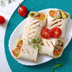 Fresh tortilla wraps with chicken, mushrooms and fresh vegetables. Chicken Mexican burrito. Tasty appetizer. Dishes from pita bread. Healthy food concept