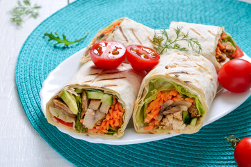 Fresh tortilla wraps with chicken, mushrooms and fresh vegetables. Chicken Mexican burrito. Tasty appetizer. Dishes from pita bread. Healthy food concept