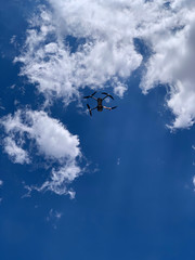 Plakat Latest technology drone or UAV shot in clear blue sky with some clouds