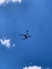 Latest technology drone or UAV shot in clear blue sky with some clouds