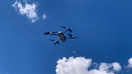 Latest technology drone or UAV shot in clear blue sky with some clouds