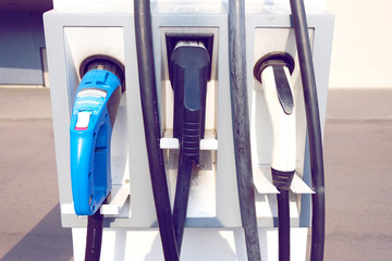 Power supply for electric car charging. Electric car charging station. Close up of the power supply plugged into an electric car being charged.