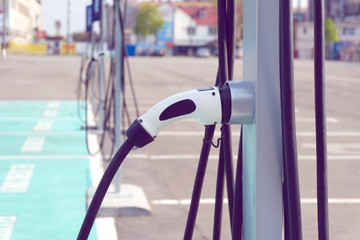 Power supply for electric car charging. Electric car charging station. Close up of the power supply plugged into an electric car being charged.