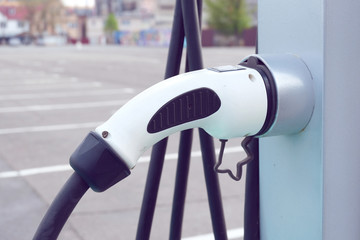 Power supply for electric car charging. Electric car charging station. Close up of the power supply plugged into an electric car being charged.