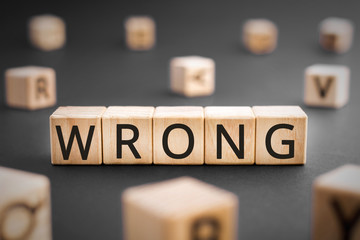 Wrong - word from wooden blocks with letters, incorrect false wrong concept, random letters around...