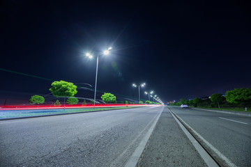 empty asphalt road and street lights at night