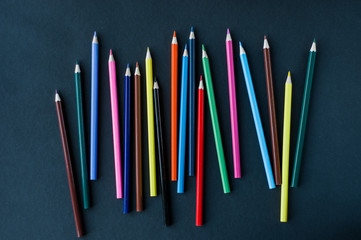 Colored pencils background.Color pencils on dark purple background.Close up. Many different colored...
