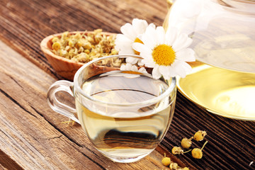 chamomile cup of tea with chamomile flowers on wooden rustic table