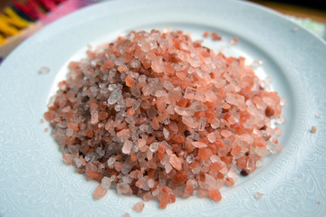 pink himalayan salt on white plate and blurred background