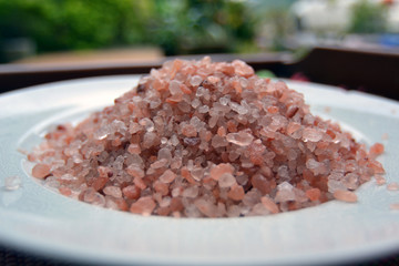 pink himalayan salt on white plate and blurred background