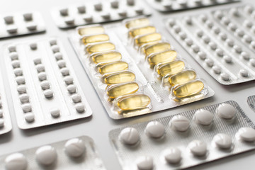 Close up of medicine pills or capsules in blister packaging arranged in lines. Pharmaceutical industry concept.