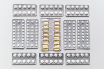 Close up of medicine pills or capsules in blister packaging arranged in lines. Pharmaceutical industry concept.