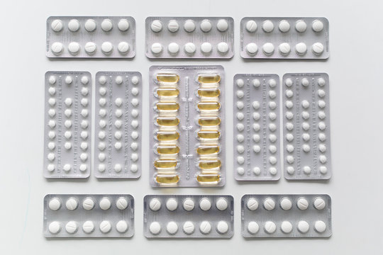 Close up of medicine pills or capsules in blister packaging arranged in lines. Pharmaceutical industry concept.