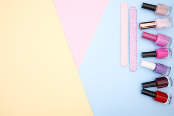 Nail accessories, nail polishes on colorful background 