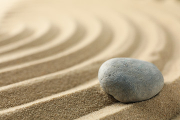 Fototapeta na wymiar Stone on the sand with patterns. Zen concept