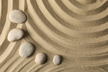 Fototapeta na wymiar Stones on the sand with patterns. Zen concept
