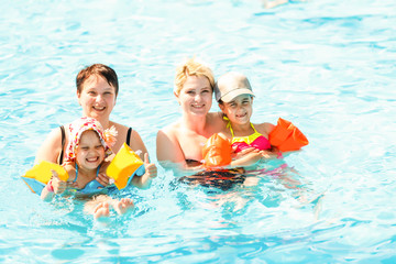two women and their children in the pool