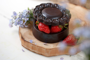 Chocolate basket with strawberries, yes on a wooden board.

