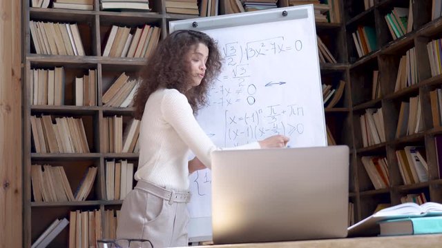 Young hispanic latin female math school teacher tutor giving online class lesson by laptop computer zoom pc app video conference call teaching webinar tutorial course explaining distance lecture.