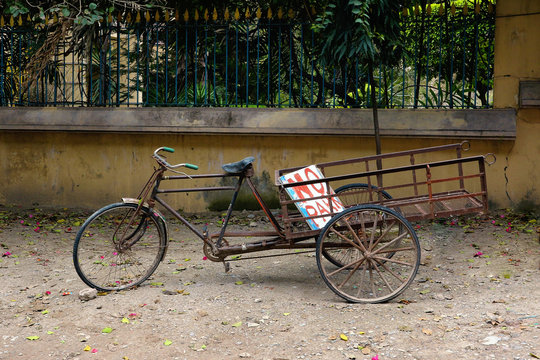 A bicycle trolley with the sign "Do not park" stands near the fence. The owner puts a bicycle cart to block the private territory from extraneous cars.