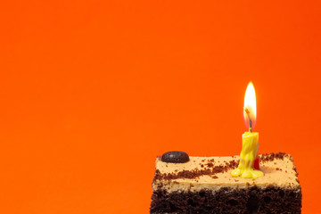 Small candle on a pie on a bright red background