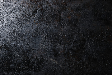 Black isolated textured background photographed with studio light.
