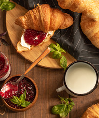 
breakfast. with croissants a glass of milk and jam