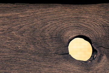 A big hole in the fence. Wooden texture with a hole from a loose knot. For design on the subject of...