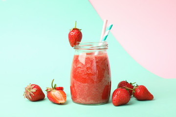 Glass jar with strawberry cocktail on two tone background. Summer drink