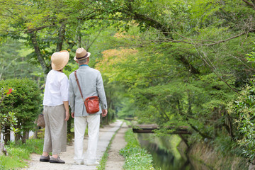 Senior couple walking along riverside footpath