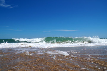 empty sea sandy shore, white waves and sky