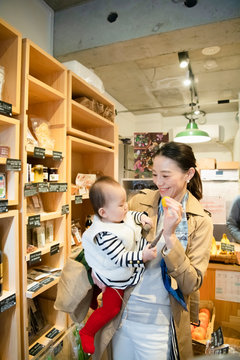 Woman shopping for organic vegetables with baby