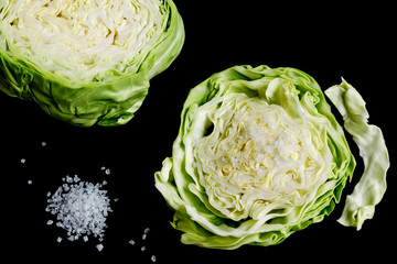 white cabbage slice and coarse sea salt on a black background