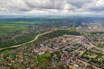 Fototapeta na wymiar Aerial view of town or city with rows of buildings and curvy streets in summer. Urban landscape from above.