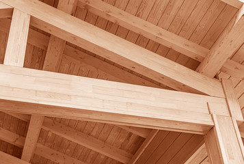 Naklejka na ściany i meble The construction of the wooden roof. Detailed photo of a wooden roof overlap construction.