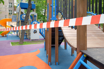 A closed playground in the yard of the house. COVID-19 safety and security measures.