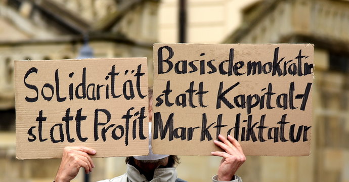 Transparent auf einer Demo: "Solidarit&auml;t statt Profit. Basisdemokratie statt Kapital + Marktdiktatur"