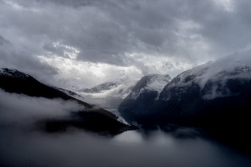 Fototapeta na wymiar Wysokie szczyty górskie pokryte gęstą mgłą