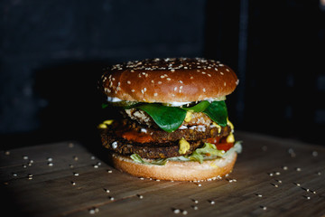 hamburger flying sesame seeds on black backround