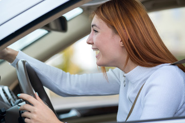 Closeup portrait of pissed off displeased angry aggressive woman driving a car shouting at someone with hand fist up. Negative human expression consept.