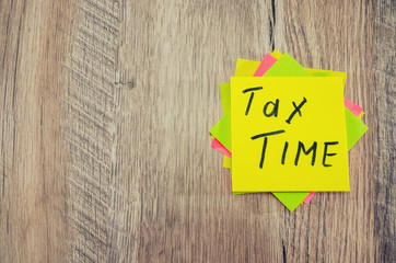 "tax time" on the sticker. Copy space. Place for text. Wood background.