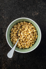 Puffed wheat covered with honey in bowl.