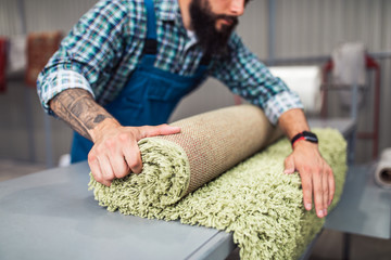 Professional worker doing his job at carpet washing service.