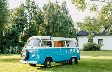 Blue classic retro vehicle parked near hangar. Classic Blue van with sunlight - obrazy, fototapety, plakaty