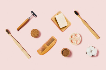 Zero waste accessories on pink background. Bathroom accessories on pink background. Natural bamboo toothbrush, sponges, cotton flowers, shaving brush. Flat lay, top view.