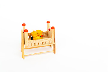 Toy teddy bears sit toy beds. Toy wooden bed. Wooden toy bed with a cute pair of teddy bears. Cute wooden decor