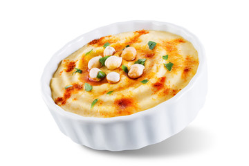 Hummus appetizer in a white bowl on a white isolated background
