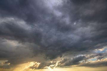 Sunset sky covered with dramatic storm puffy clouds before rain.