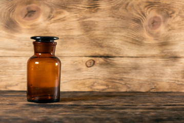 Empty brown glass bottle on the wooden table background.